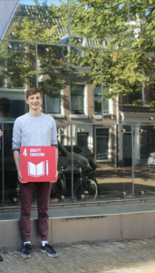 Tomas van Hernon stagiair van SPARK the Movement houdt een SDG 4 - kwaliteitsonderwijs bord vast 